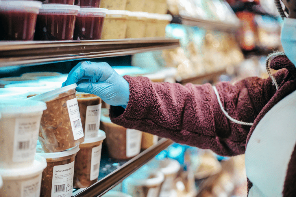 Client face au pot de confiture d'un magasin d'alimentation